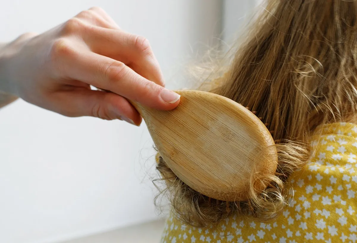 Правильная техника расчесывания сухих волос с использованием деревянной расчески с широкими зубьями