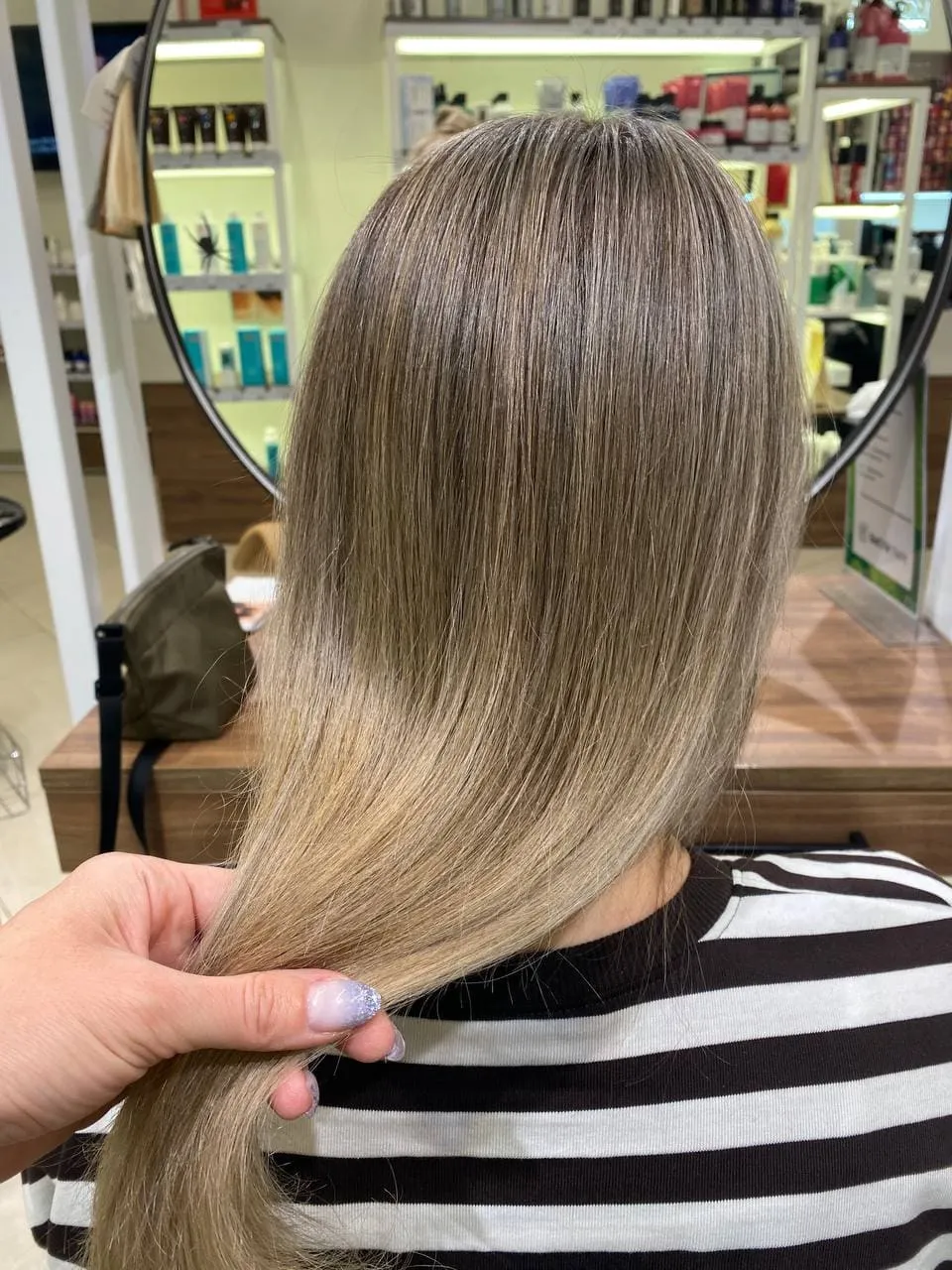 Профессиональный парикмахер выполняет сложное окрашивание и стрижку, определяющие итоговую цену услуги