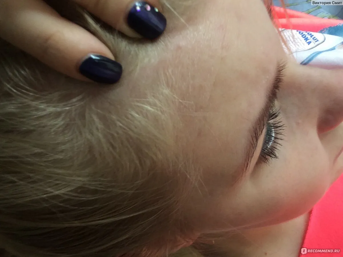 Молодая мама с ребенком на руках задумчиво смотрит на выпавшие волосы на расческе, проблема выпадения волос после родов