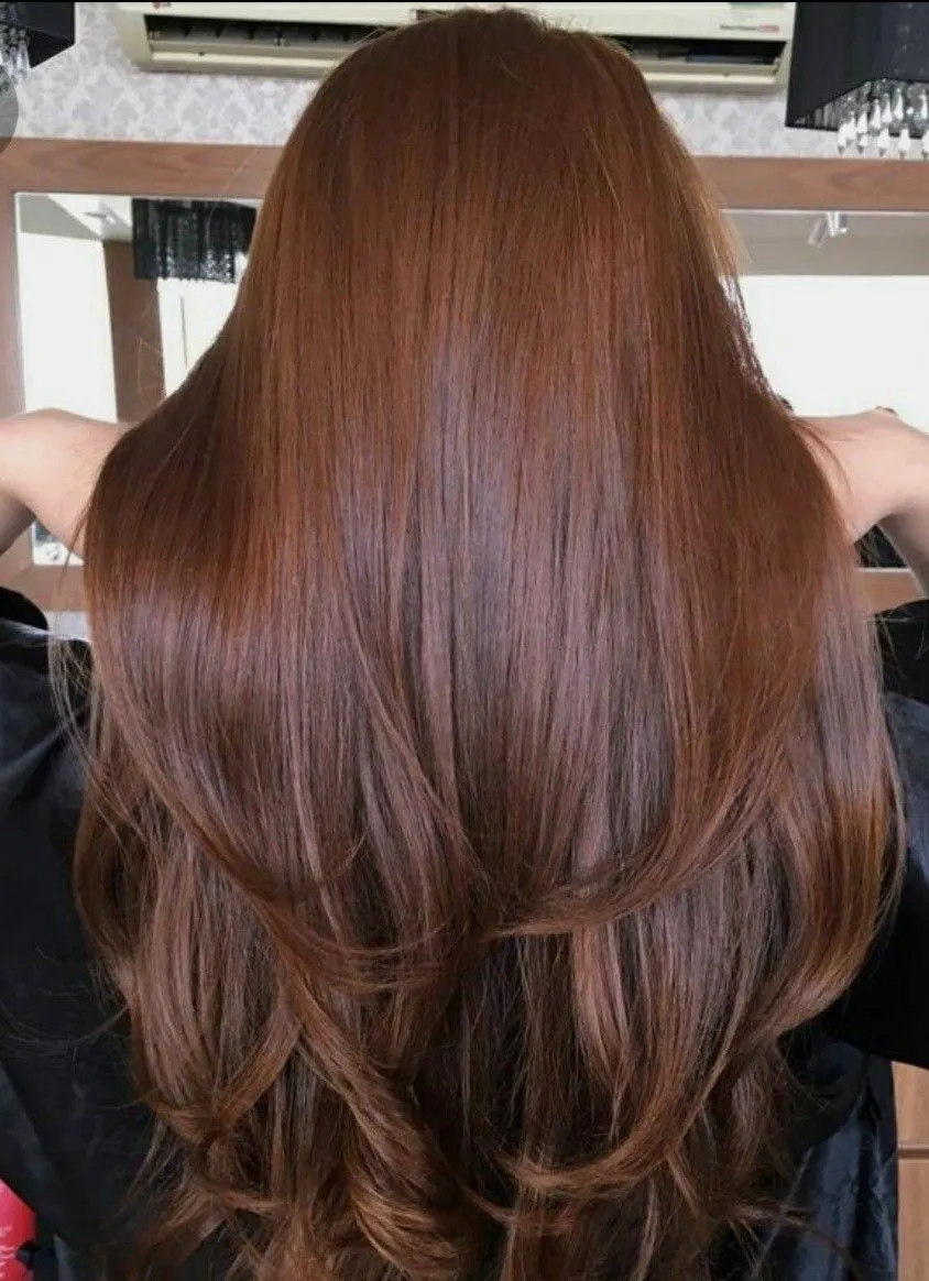Медный оттенок волос: насыщенный цвет и ухоженные пряди Яркий медный оттенок волос на длинных вьющихся прядях с естественным блеском и переливами на солнце