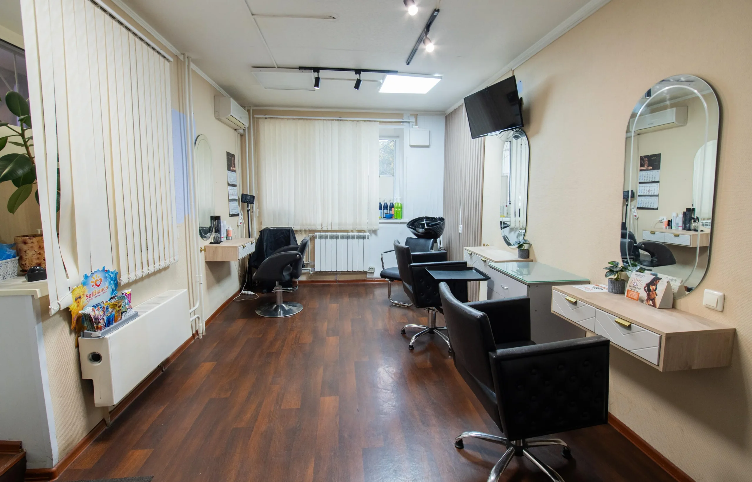 Женщина с идеальной средней стрижкой каскад в салоне красоты, читает отзывы на планшете