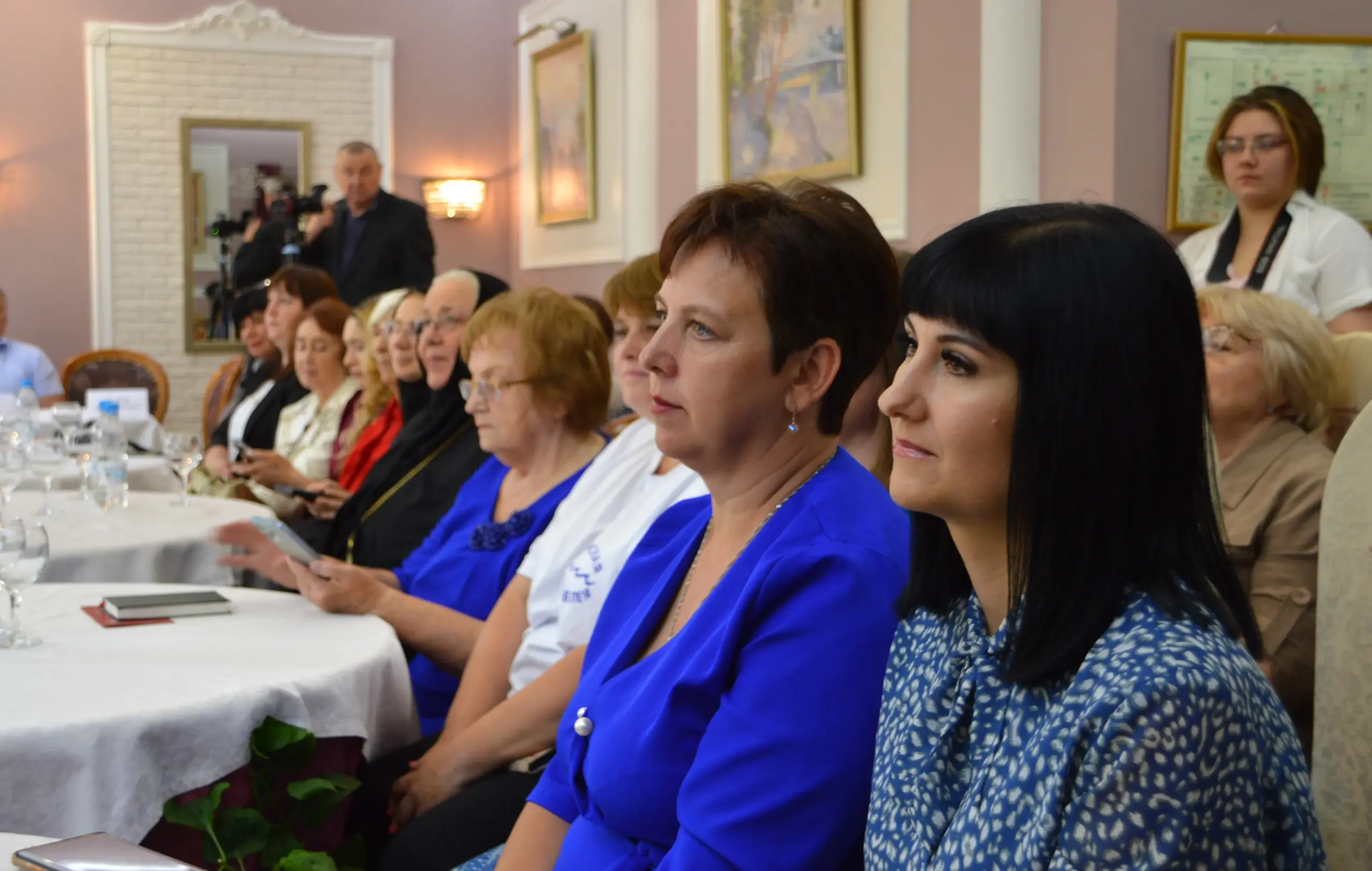 Церемония награждения конкурса Женщина года: победительница на сцене с наградой, аплодирующий зал