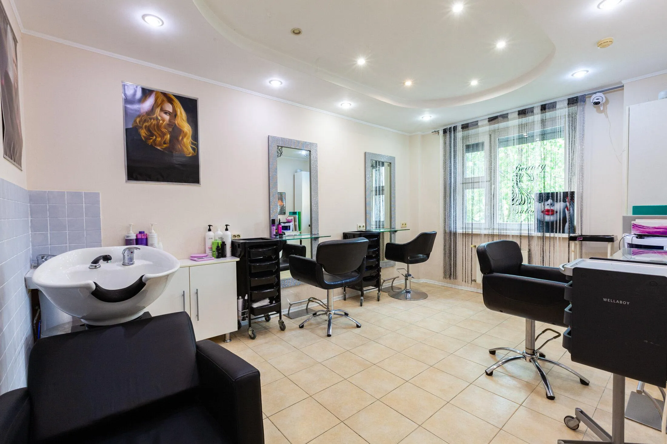 Интерьер современной женской парикмахерской с клиенткой и стилистом за консультацией по стрижке