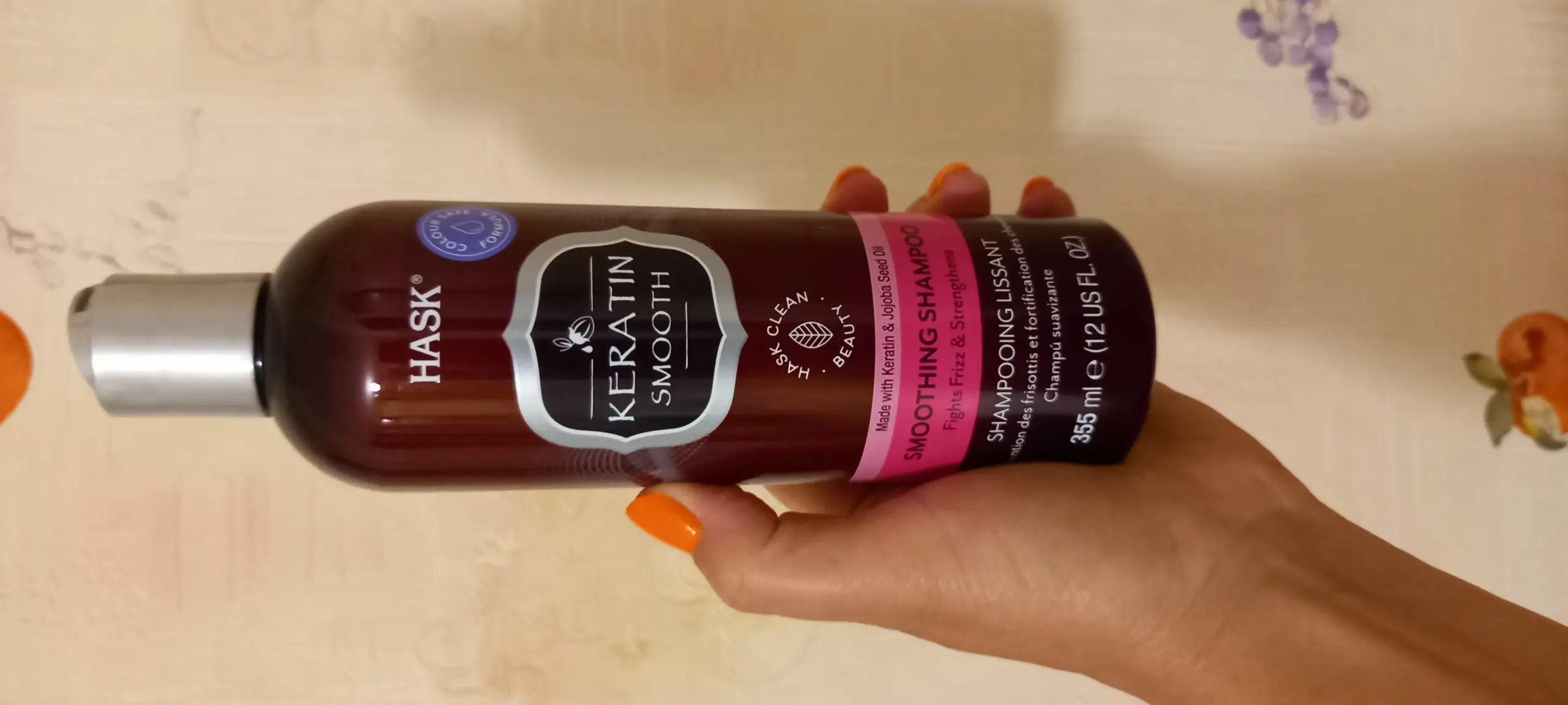 Шампунь с кератином для волос на полке ванной комнаты, флакон с надписью Keratin, рядом расческа и полотенце