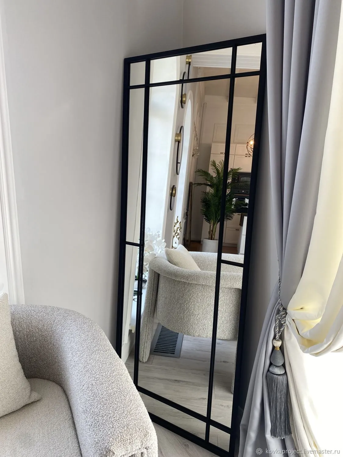 Использование зеркала в интерьере гостиной для расширения пространства Современный интерьер гостиной с большим декоративным зеркалом в резной раме, визуально расширяющим пространство и отражающим свет от окна