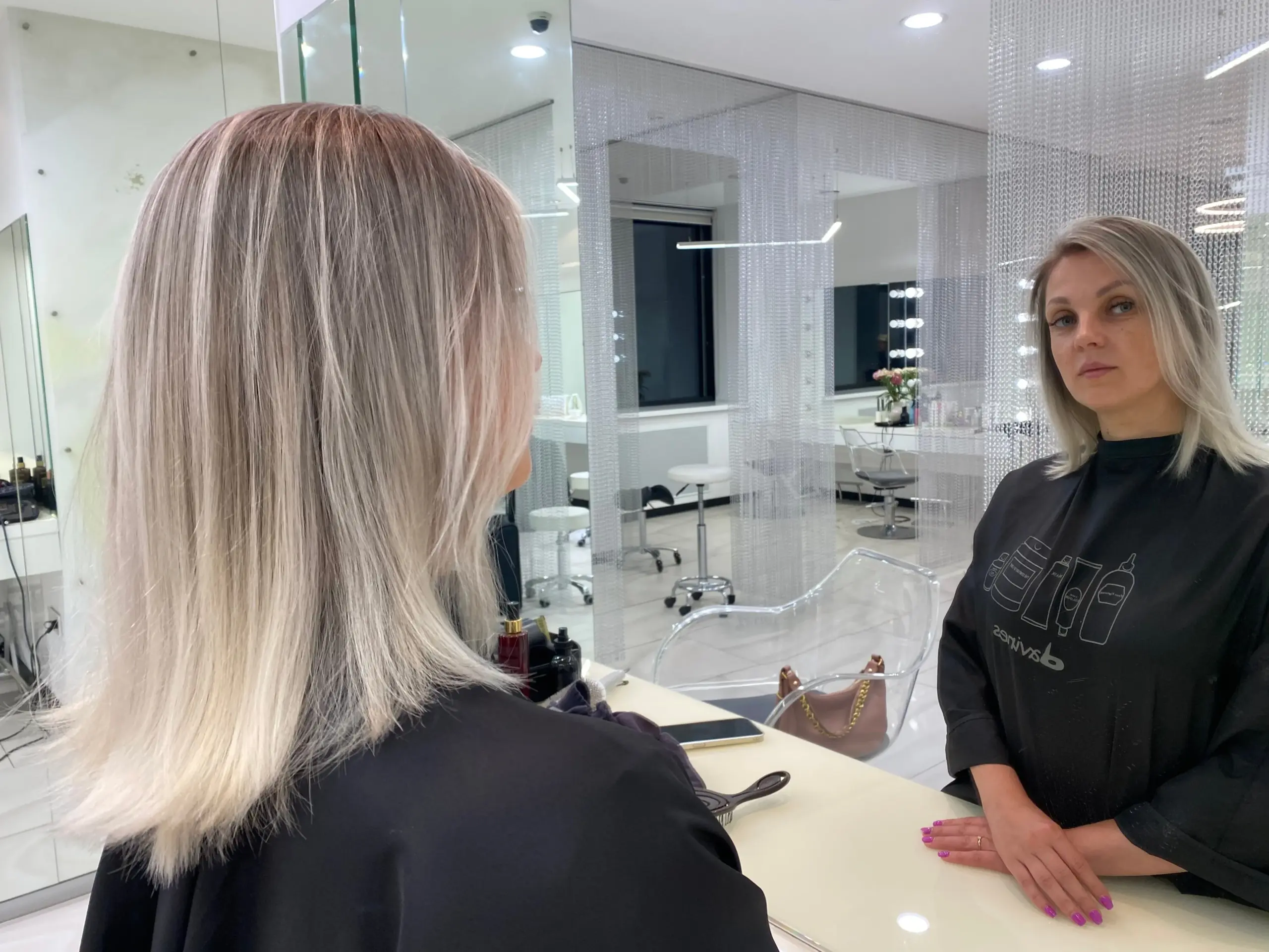 Работа мастера: искусство создания идеальной прически Профессиональный женский парикмахер за работой: создание сложной укладки и окрашивания в современном салоне красоты